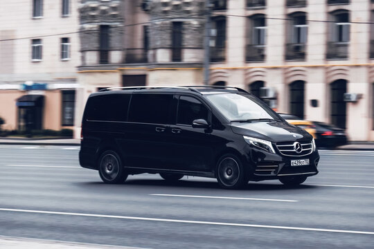 Black van Mercedes-Benz W447 Viano in the city street in motion. Premium minivan car rushes on highway, side view