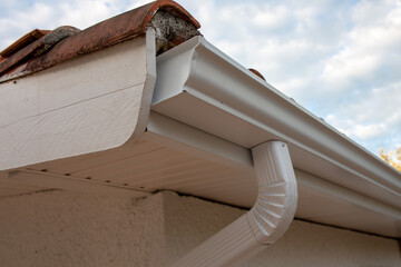 Cleaned white new aluminum gutter rain systems and drain pipes on restoration house