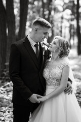 the groom and the bride are walking in the forest