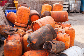 A pile of old used gas cylinders of small size. Scrap metal from gas cylinders.