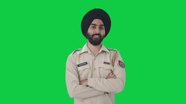 Happy Sikh Indian police man standing Green screen