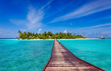 Jetty over blue ocean leading to sandy beach of tropical island, beautiful sky, green palm trees, maldives islands - obrazy, fototapety, plakaty