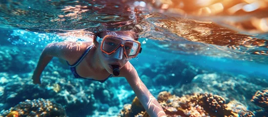 Tuinposter Child snorkeling Kids swim underwater Beach and sea summer vacation with children Little girl watching coral reef fish Marine life on exotic island Kid swimming and diving with snorkel and mask © HN Works