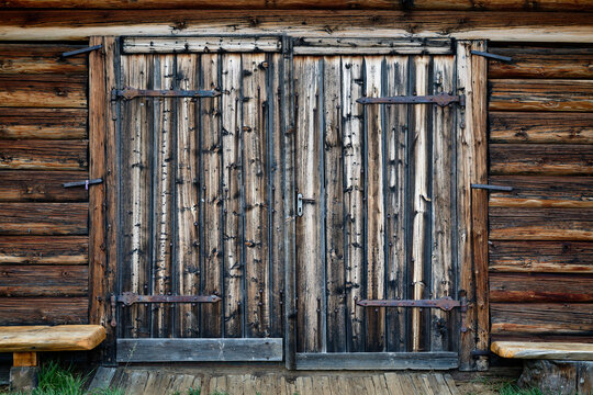 Closed ancient wooden gate of old farm house with handle. Beautiful weathered wood background.