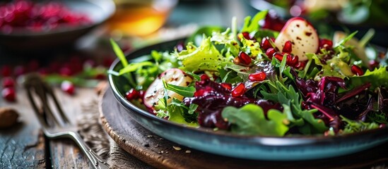 Colorful winter salad with mixed greens Belgian endives and pomegranate seeds. Creative Banner. Copyspace image - obrazy, fototapety, plakaty