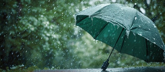 Broken green umbrella in park on rainy day with hail. Creative Banner. Copyspace image