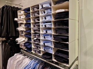 the wardrobe with shelves is clearly divided by color and type of clothing. shirts with collars in...