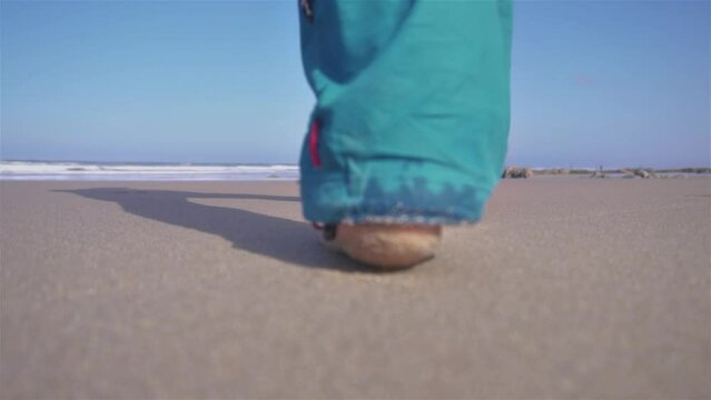 Man walk barefoot on sand beach in sunny ocean coast nature, slow motion outdoor travel