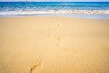 View of the ocean waves, sandy beach and sky.