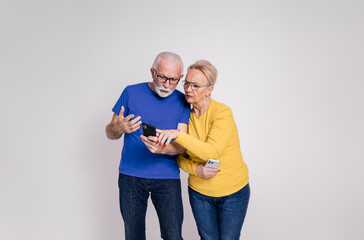 Suspicious senior husband checking wife's messages over mobile phone on isolated white background