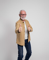 Portrait of smiling senior male entrepreneur in eyeglasses gesturing thumbs up on white background