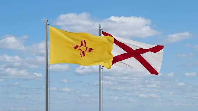Alabama and New Mexico US state flags waving together on cloudy sky, endless seamless loop
