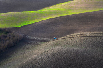 Tractor plowing the fields in Tuscany. Volterra, Italy