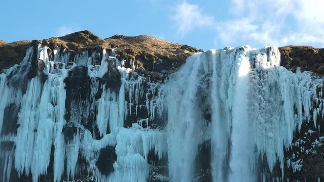 Iceland. Waterfall and Ice. Frozen waterfall in winter, a magical winter landscape. Beautiful nature of the north. Pure glacial water. Famous waterfall in Iceland