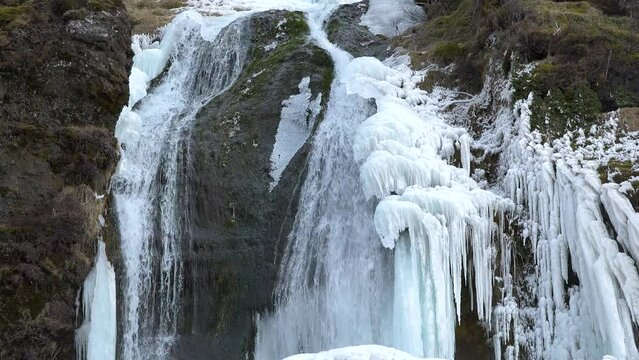 Iceland. Waterfall and Ice. Frozen waterfall in winter, a magical winter landscape. Beautiful nature of the north. Pure glacial water. Famous waterfall in Iceland