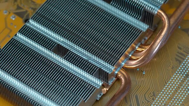 Powerful radiator with copper tubes for circulating coolant to cool the computer video card. Closeup. Macro. Shallow depth of field. Shot in motion
