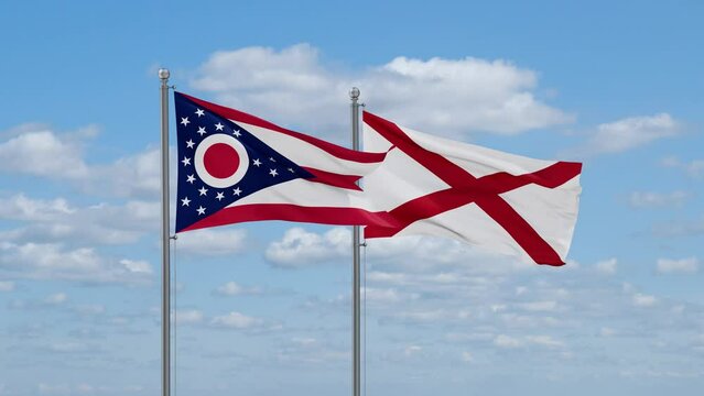 Alabama and Ohio US state flags waving together on cloudy sky, endless seamless loop