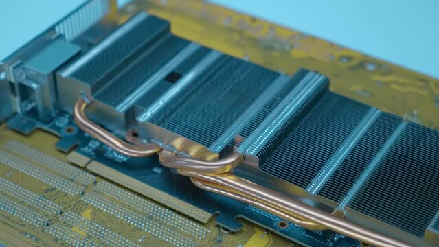 Powerful radiator with copper tubes for circulating coolant to cool the computer video card. Closeup. Macro. Shallow depth of field. Shot in motion