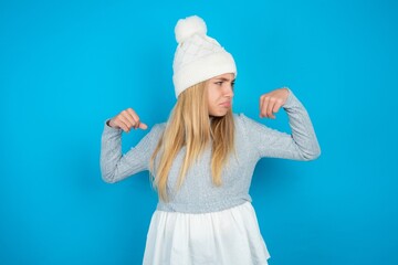 beautiful caucasian teen girl wearing grey sweater showing arms muscles smiling proud. Fitness...