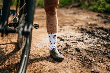Close up shot of leg sprayed with mud of a mountainbiker using high end mountainbike
