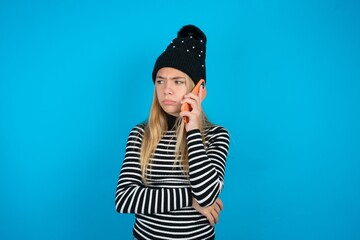 Sad beautiful caucasian teen girl wearing striped sweater talking on smartphone. Communication...
