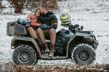  A romantic couple shares a tender embrace and kisses while joyously riding a quad through the...