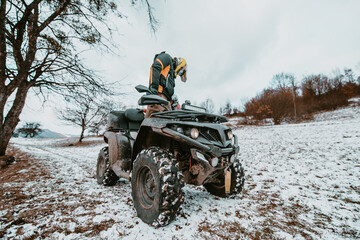  An adventurous couple prepares for an exhilarating quad ride through the forest, embodying...