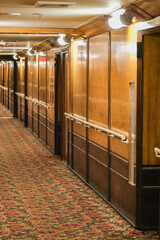 Wooden paneled cabin corridor hallway aisle to staterooms and suites onboard legendary ocean liner cruiseship cruise ship