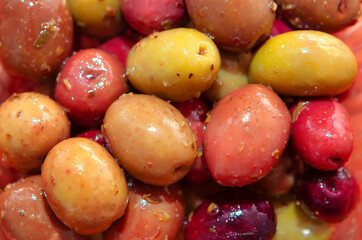 Close up of pickled olives in red and green colors at background