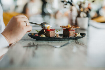 Woman eating culinary dessert with a spoon in a restaurant