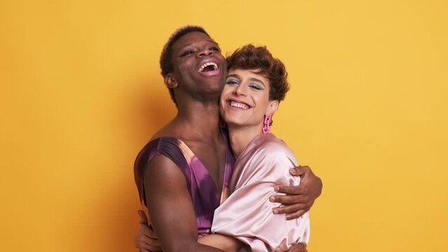 Stylish trans people in make up and fashion clothes embracing and smiling