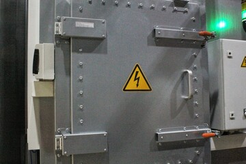 High voltage sign on the wall of a gate power plant. Industrial safety warning sign. Electricity...