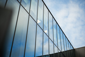 Beautiful glass panels on a business building showing reflections of the sky.