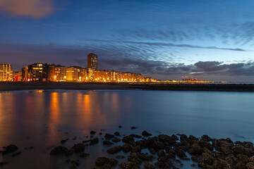 Oostende (Ostend) city skyline by North Sea beach after sunset with night lights, Flanders, Belgium.