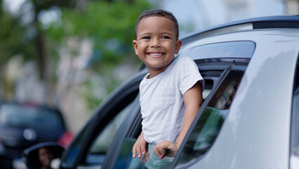 Little kid looking out car window. Summer trip with family. Happy boy excited to travel with family. Dream kid. Happy family traveling by car. Smile of kid in car window
