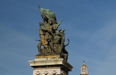 Fototapeta na wymiar Statue On The Top Of The Vittorio Emanuele II Monument In Rome Italy On A Wonderful Spring Day With A Few Clouds In The Sky