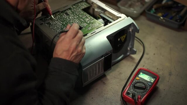 electronics repair. a man uses an ammeter. troubleshooting. slow-motion video. repair of consumer electronics. High quality video in 4k