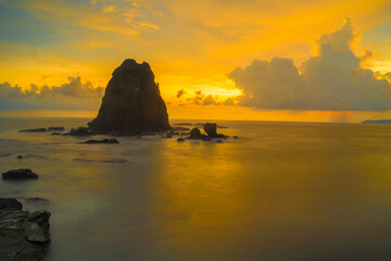 Fototapeta na wymiar Sunset at the rocky beach in Papuma, Jember, East Java, Indonesia