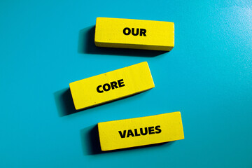 Our core values lettering on yellow wooden blocks with blue background. Business concept photo. Top...