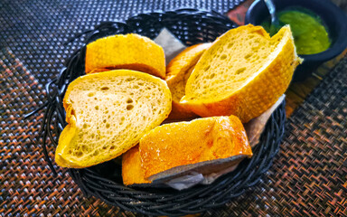 Bread in basket and green coriander sauce restaurant Mexico.
