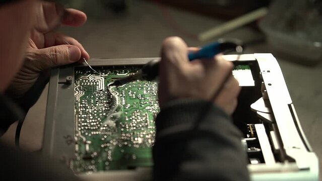 electronics repair. repairing consumer electronics. soldering an electronic board. close-up of an electronic board. slow-motion video. High quality video in 4k