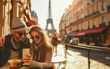 Tuinposter Couple taking selfie at Paris cafe with Eiffel Tower view. Shallow field of view. © henjon