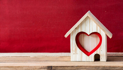 Obraz na płótnie Canvas House wood with heart shape on wooden and red background, copy space