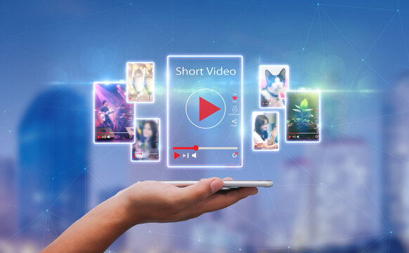Short Video marketing concept.Man hands holding mobie phone short video player with blurred city as background