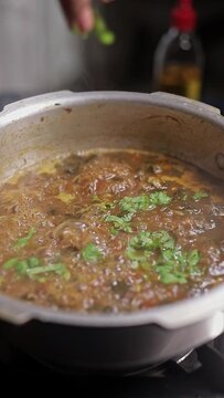 A video of preparing indian spicy curry with moringa leaves inside the kitchen