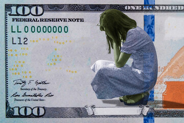 The texture of a hundred-dollar American bill with the image of a crying girl.