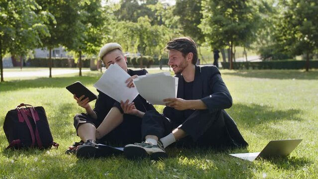 Success career of young woman helps business assistant review agreements with partners on nature background. Colleagues holding documents in park. Two people count profit papers.