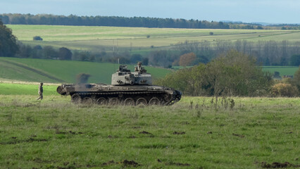 a soldier directing an FV4034 Challenger 2 II main battle tank across a field. Wilts UK