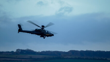 British army Boeing Apache Attack helicopter gunship (AH64E AH-64E ArmyAir606) in low level flight,...