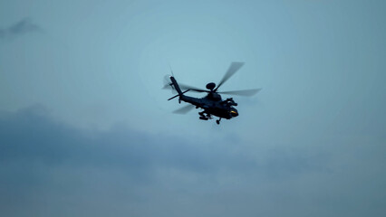 British army Boeing Apache Attack helicopter gunship (AH64E AH-64E ArmyAir606) banking hard in flight, Wiltshire UK